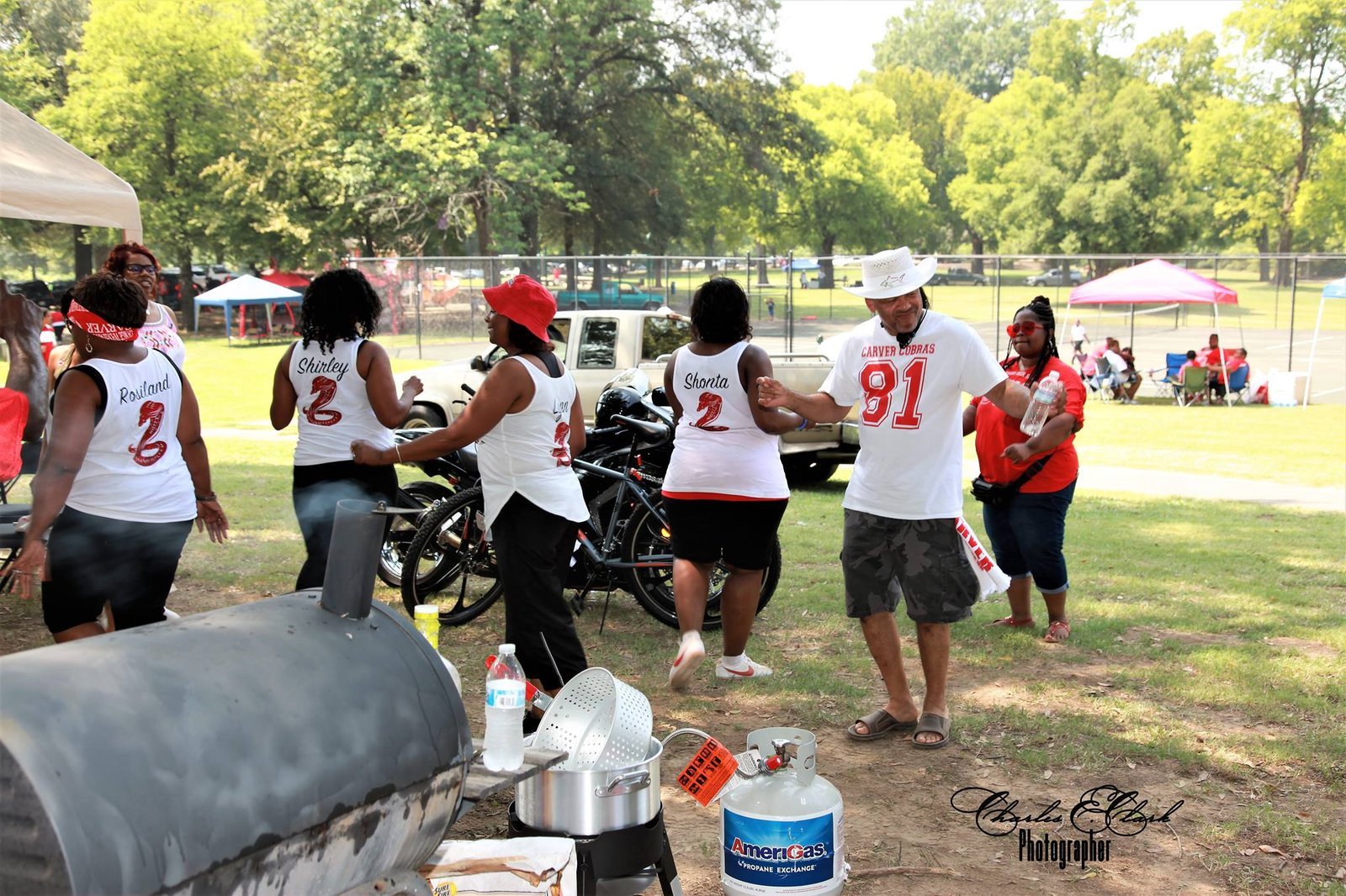 Alumni group at outdoor park reunion event with bikes
