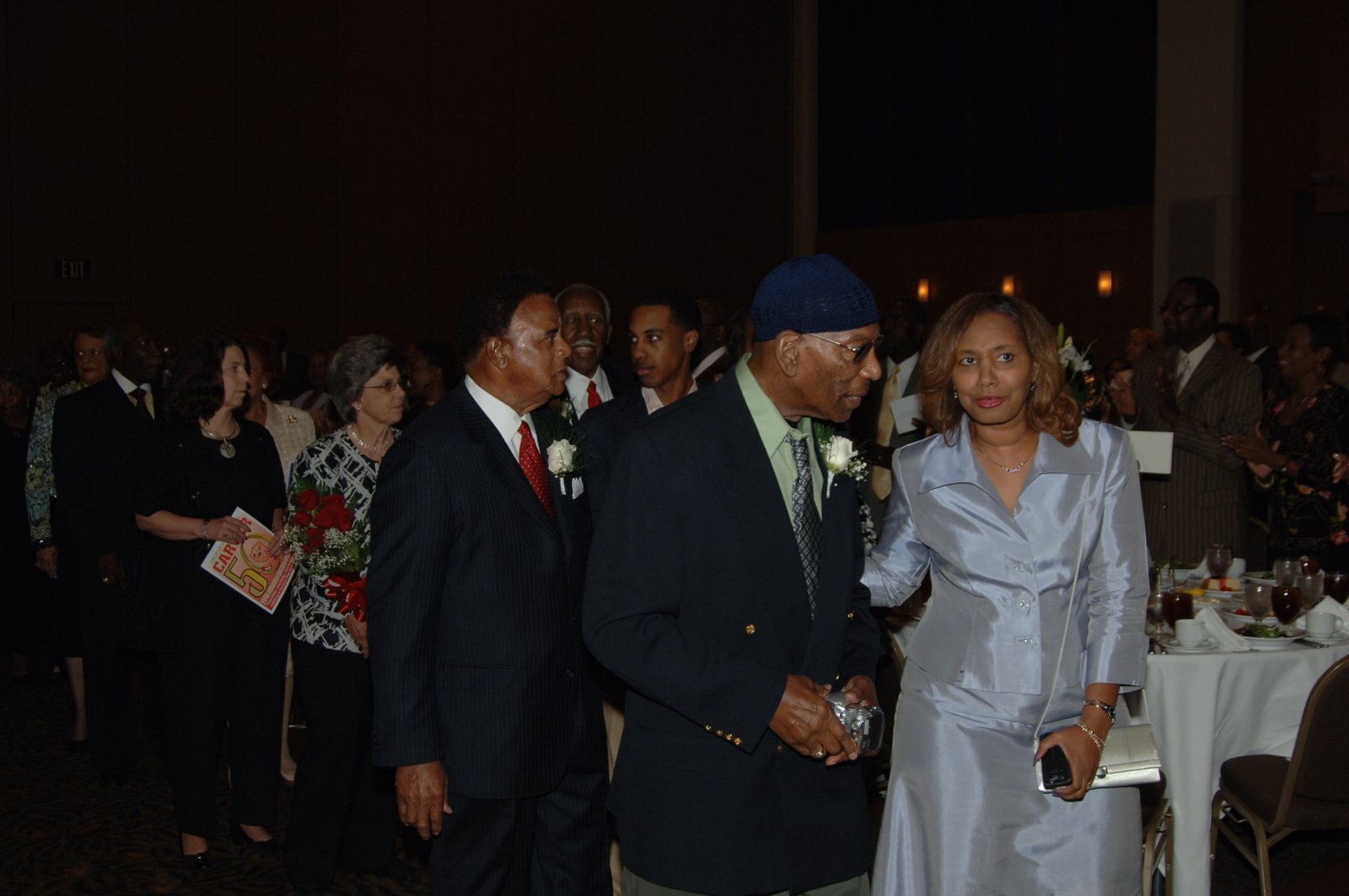 Formal event photo with alumni in elegant attire at banquet