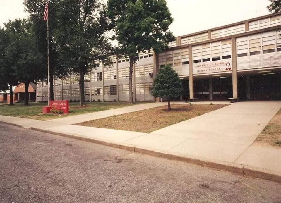 Carver High School building exterior with red sign and American flag